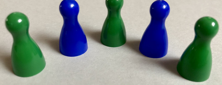 Five playing pieces in green and blue color, arranged in a semicircle.