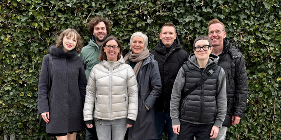 Gruppenfoto mit den sieben Projektmitgliedern vor einer Hecke.