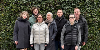 Gruppenfoto mit den sieben Projektmitgliedern vor einer Hecke.